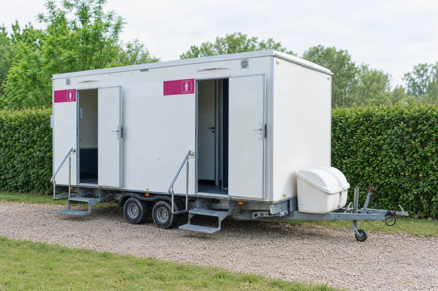Toilettenwagen mit getrennten Eingängen an einer Veranstaltungslocation